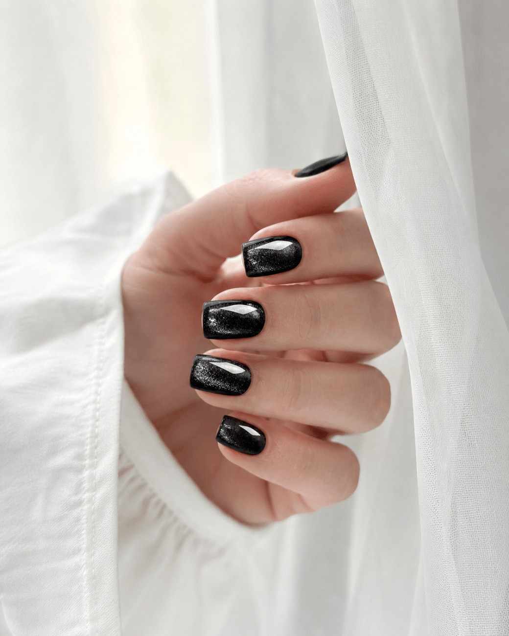 Black Aura reusable press-on nails worn on hand