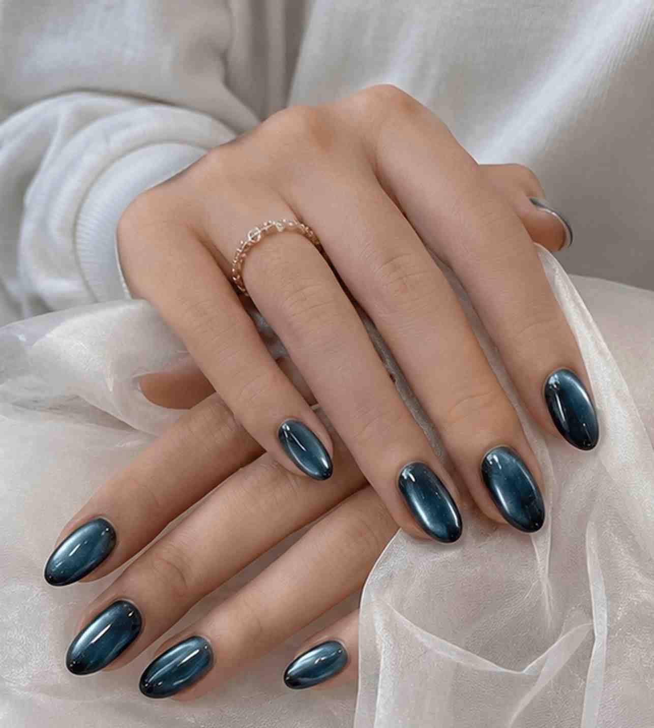 Close-up of Green Galaxy nails showcasing the reflective green cat-eye shimmer and glossy finish.