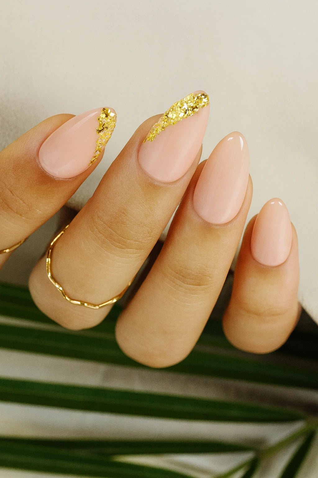 nude pink base colour on thumb, ring & pinky finger on other side index and middle finger carry a gold foil side french design on the tip