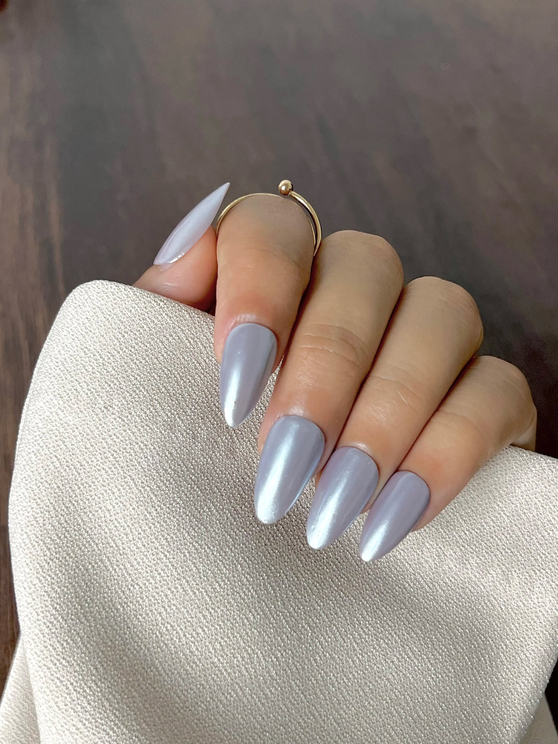 Closeup of the hand with silver chrome long fake artificial nails in almond shape