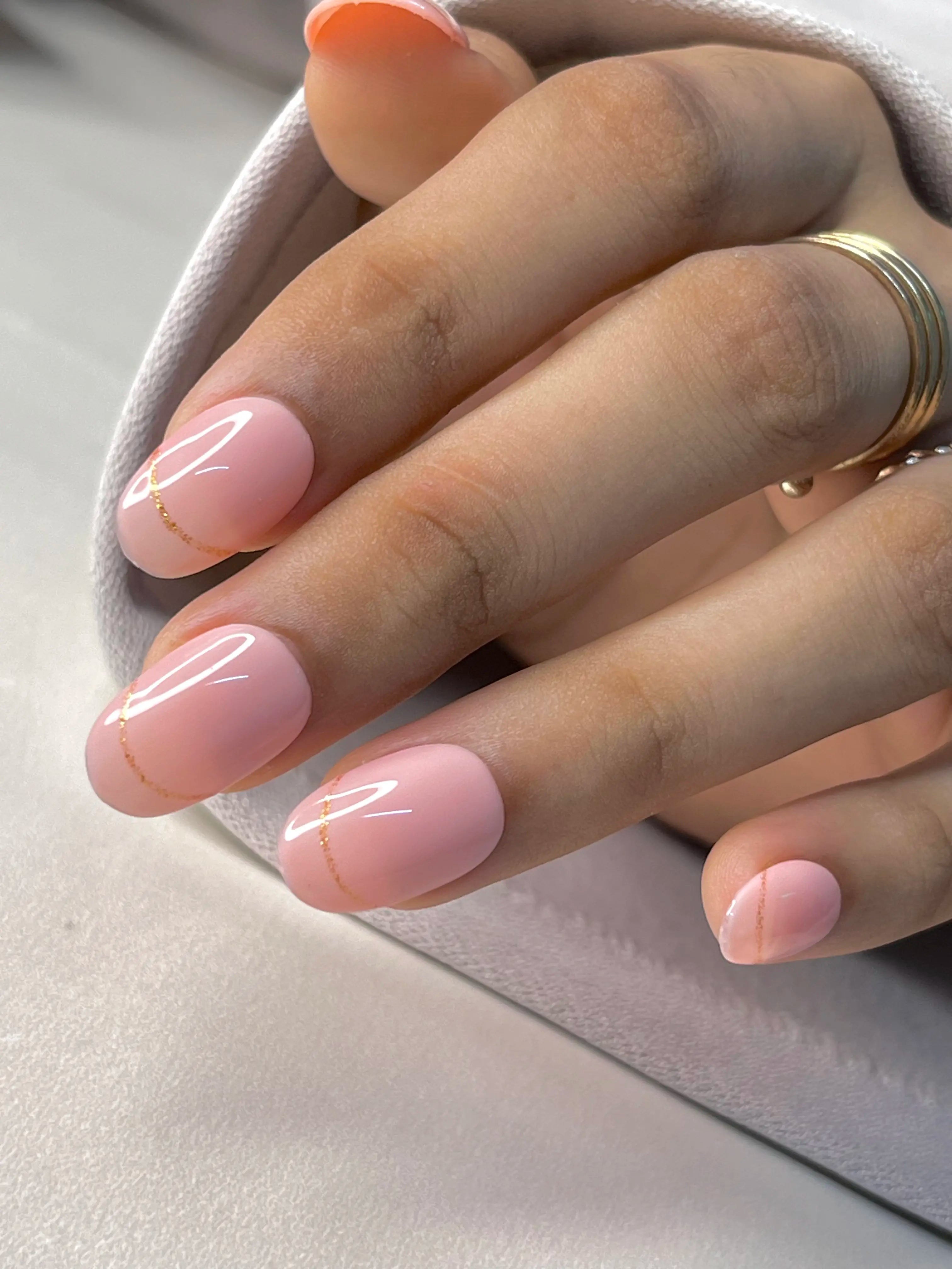 single hand  image of short round nude pink with glitter french fake nails
