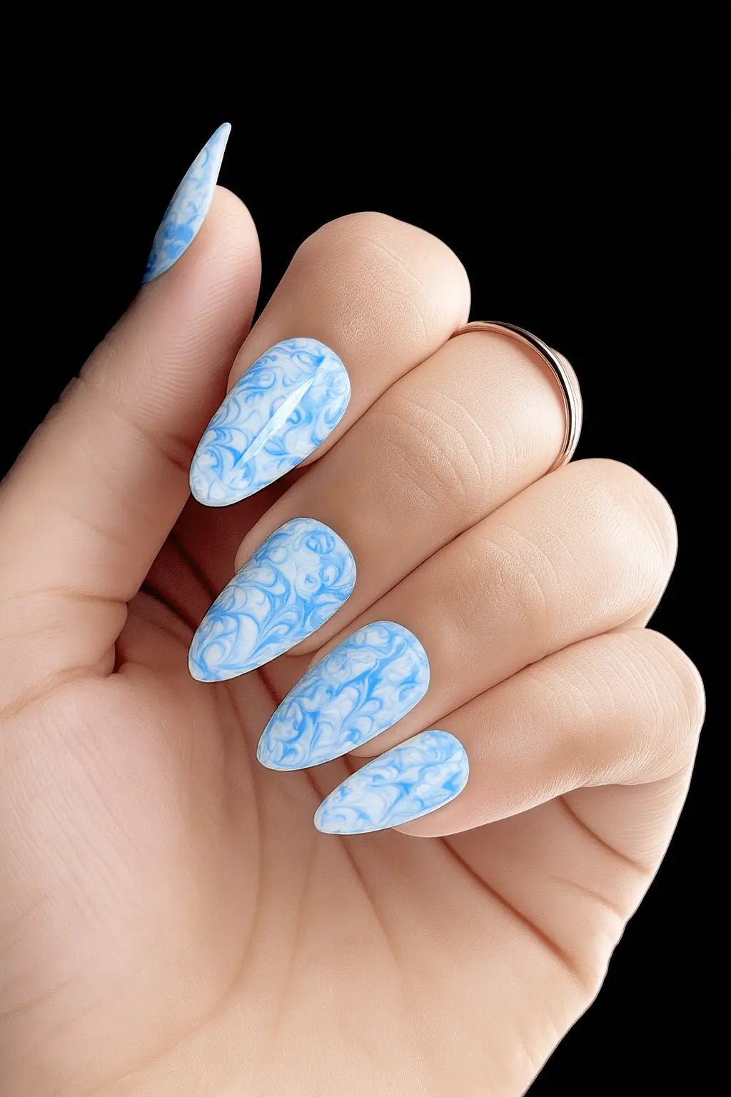 Elegant blue artificial nails with marble texture and glossy finish
