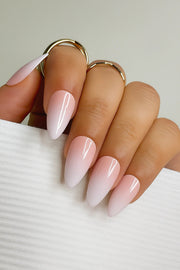 Hand with pink and white ombre fake nails on a neutral background